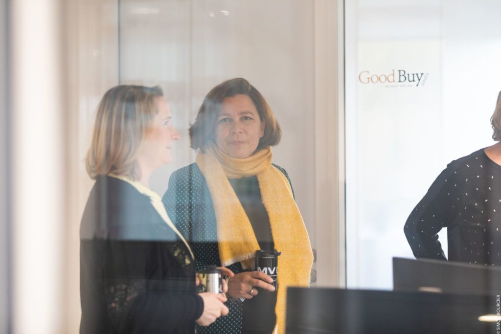 Deux personnes devant une vitre avec logo GoodBuy media